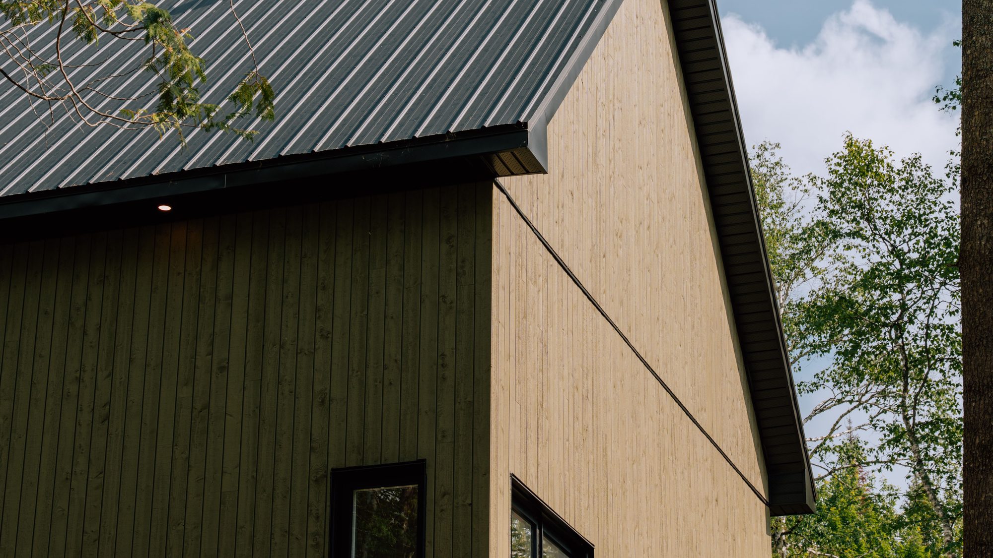 Pignon d'une maison Karborea, revêtement de bois et toiture en acier